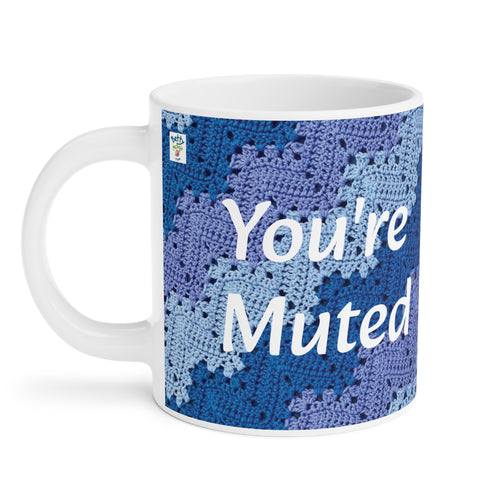 Coffee mug with purple and blue crochet print in the 6-Day Kid Blanket Snowflake Effect pattern, Betty McKnit logo and white lettering that says 