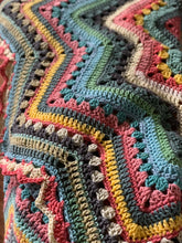 Load image into Gallery viewer, Angled close-up of coral, blue, yellow, teal, and charcoal crochet stripes, showing granny clusters and open stitchwork.


